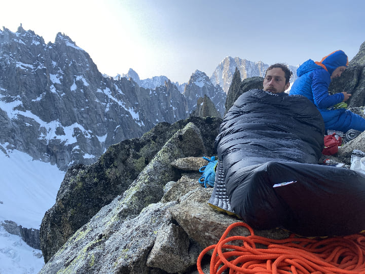 Alpinista leží ve spacáku Rab v horách
